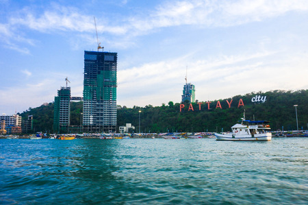 White boat with Pattaya city landmarkのeditorial素材