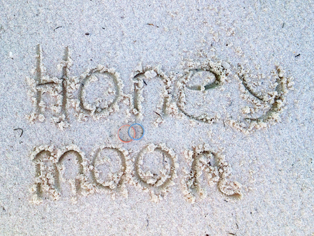 Honeymoon writing at the sand. Beach with wedding rings and honey moon sign.の写真素材