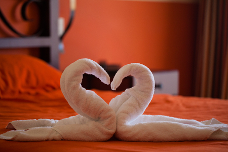 Towels decorated figures of swan in hotel room at the bedの写真素材