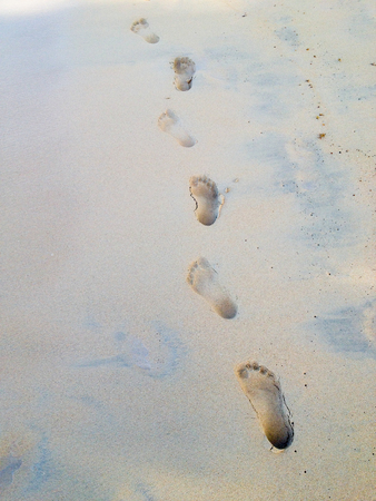 Footprints at sand, foot of woman and man. Vacation in summerの写真素材