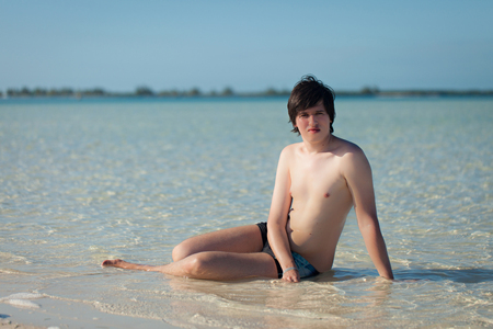Young man sunbathing at wild beachの写真素材