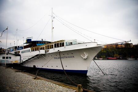 STOCKHOLM, SWEDEN - NOVEMBER 1, 2008: City street in Stockholm Sweden. Old sailing ship at the pier at cloudy dayのeditorial素材