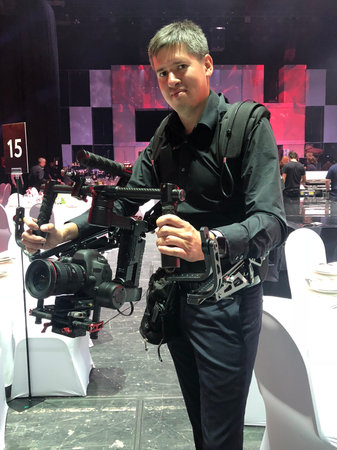 Cameraman videographer with professional camera and electronic steadicam indoors