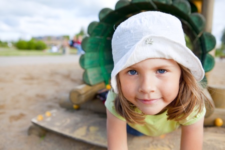 small girl playing on children's playgroundの写真素材