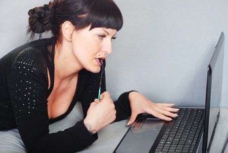 brunette woman working with laptop in homeの写真素材
