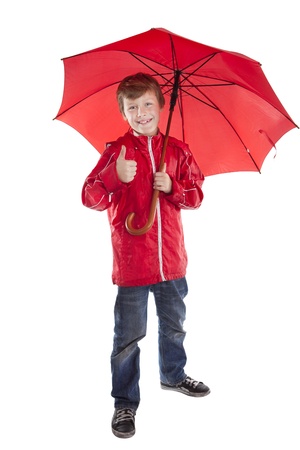 portrait of boy holding red umbrella over white backgroundの写真素材