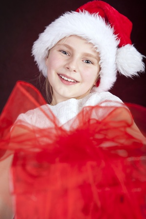 smiling young girl holding christmas presentの写真素材