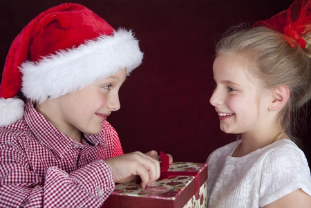 christmas boy giving present to smiling girlの写真素材