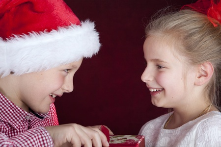 christmas boy giving present to smiling girlの写真素材