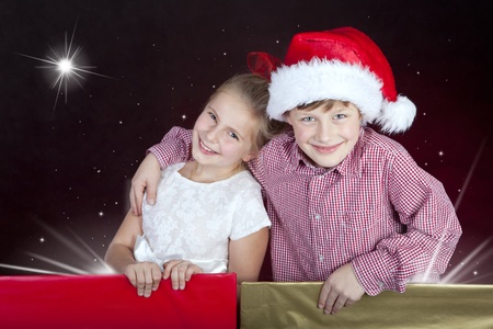 girl and boy in christmas hat in present boxesの写真素材