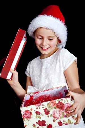 smiling girl holding christmas present over darkの写真素材