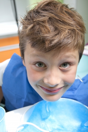 Young boy drinking water after dental operationの写真素材