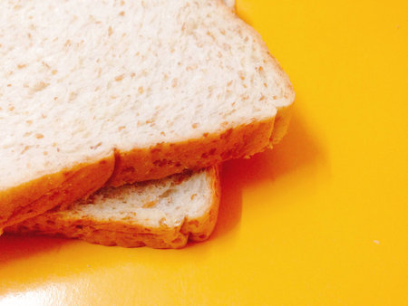 Fresh whole wheat bread placed on a yellow background.の写真素材
