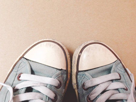 Dirty shoes top view of blue sneakers display on brown background. Vintage effect.の写真素材