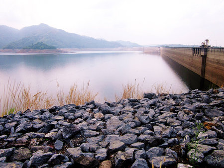There is a vast reservoir behind the mountains.の写真素材