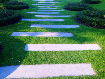 A cement walkway that is rectangular and surrounded by green grass.の写真素材