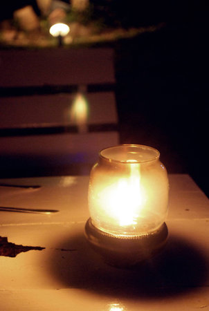 Vintage kerosene oil lantern lamp burning with a soft glow light and a candle flickering in the dark.の写真素材