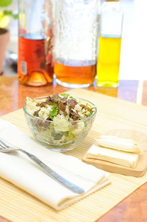 Fresh green salad in a transparent bowl on the kitchen tableの写真素材