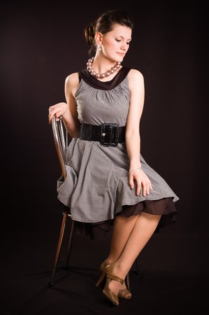 Portrait of a girl with beads in a dress in retro style on a black backgroundの写真素材