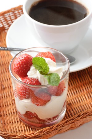 Strawberry dessert and coffee for breakfast in a wicker trayの写真素材