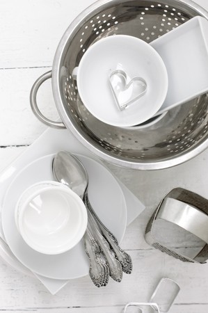 White ceramic and metal dishes on a white painted wooden floor