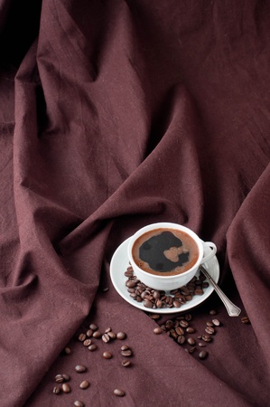 Hot coffee and coffee beans on a brown linenの写真素材