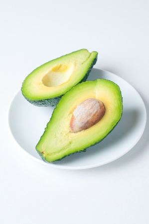 two halves of a large ripe avocado with a stoneの写真素材