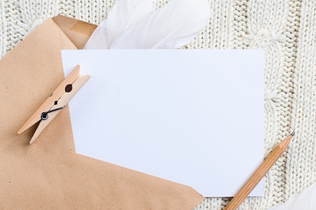 Empty cardboard card and envelope on texture of knitted sweaterの写真素材