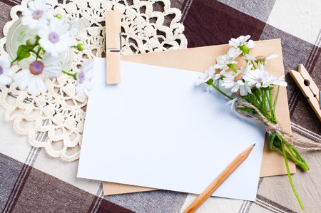 composition of the empty cardboard card with flowers and an envelope on fabricの写真素材