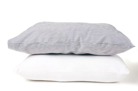 Two pillows, striped and white on a white backgroundの写真素材