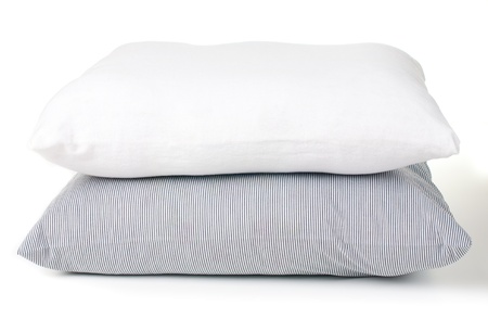 Two pillows, striped and white on a white backgroundの写真素材