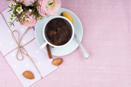 Background in pink colors with coffee, flowers and an envelope の写真素材