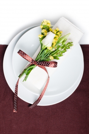 Festive table setting and decoration with fresh flowers in brown and yellowの写真素材