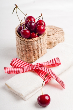 Festive table setting and decoration with fresh flowers and sweet cherryの写真素材