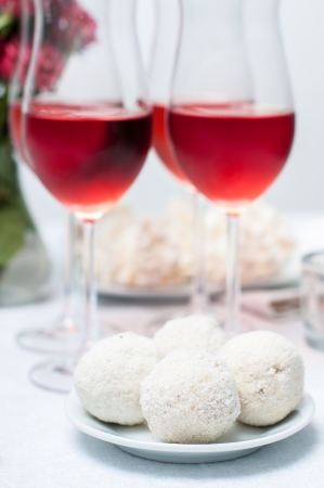Walnut-chocolate cakes and rose wine in glasses on a festive tableの写真素材