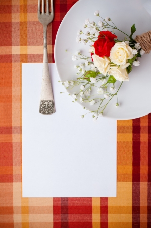 Festive table setting with flowers and vintage crockery on the bright checkered tablecloth in a country style, card templateの写真素材