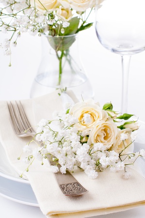 Festive table setting with roses in bright colors and vintage crockery on a white backgroundの写真素材