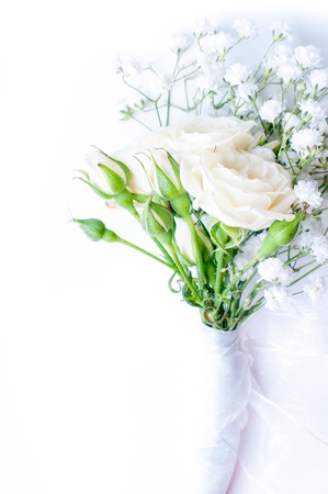 small bouquet of white roses and gypsophilas on a white tulleの写真素材