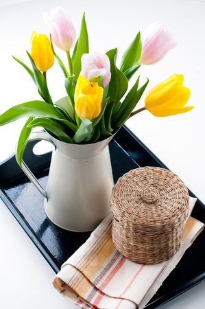 still life in a country style  a bouquet of tulips in a jar, wicker basket and a napkin on a black trayの写真素材