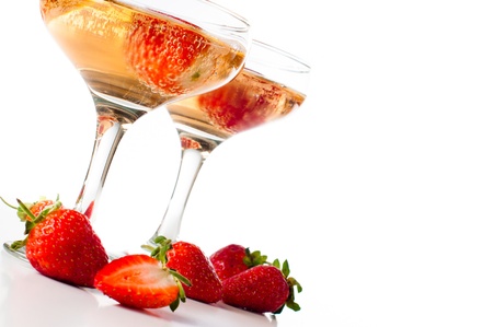 Two glasses of cold champagne with strawberries on a white background, isolated, close-upの写真素材