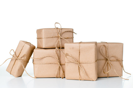 Several gift boxes, postal parcels wrapped in brown kraft paper tied with a rope on a white...