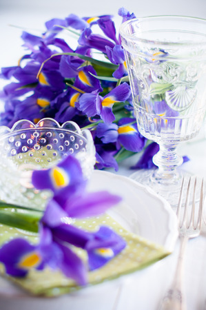 Festive table setting with purple iris flowers, vintage cutlery and candles.の写真素材
