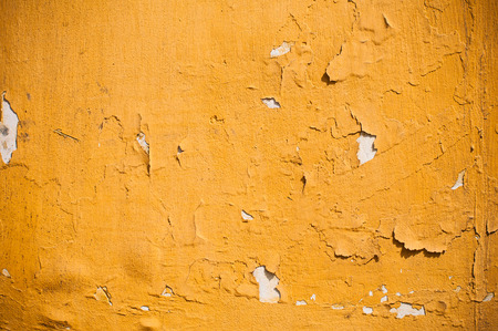 Abstract background, old cracked plaster wall, yellow and white texture, paint stains and cracks.の写真素材