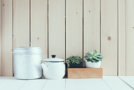 Vintage home arrangement, summer plants and enamelware on a barn wall background, soft pastel...
