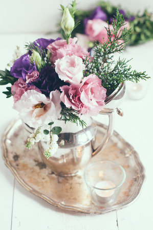 Summer bouquet of purple and pink eustomas in an antique coffee pot on a white wooden board, vintage style, holiday and wedding elegant floral decorの写真素材