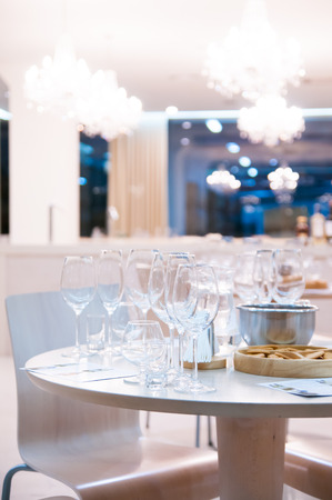 Tasting room, a bright interior with wine glasses and crystal chandeliers, empty restaurant ready for banquetのeditorial素材