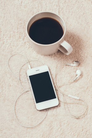 Cozy relaxing at home, coffee and player with headphones on the carpetの写真素材