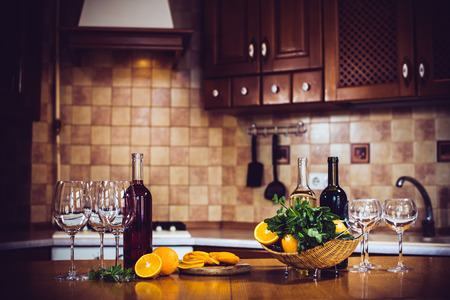 Wine bottles, crockery, glasses, fruit on the table, cozy home kitchen interiorの写真素材