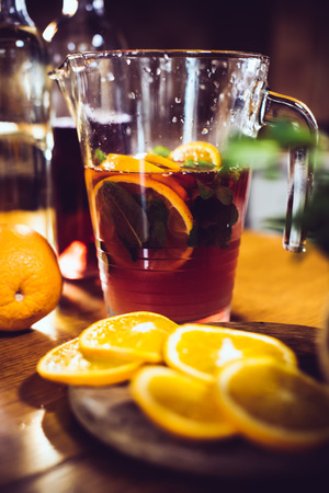 Large jar of sangria with red wine, oranges and ice for home party, home kitchen interior. Homemade food and drinksの写真素材