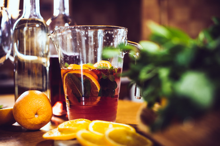 Large jar of sangria with red wine, oranges and ice for home party, home kitchen interior. Homemade food and drinksの写真素材